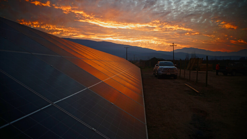 Paneles solares de INNSOLAR iluminados por el atardecer, junto a sistema de baterías BESS que aporta autonomía energética y eficiencia para empresas.